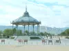 Valence - Esplanade du Champ de Mars et son kiosque Peynet entouré de chaises avec vue sur la montagne, ciel nuageux