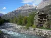 Vallouise - Bomen en huizen langs de rivier, met uitzicht op de bergen samen in het Parc National des Ecrins