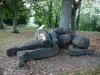 Verneuil-en-Bourbonnais - Sleeping Giant (escultura de madera) a los pies de un árbol, en la Motte Coquet