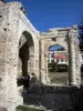 Vienne - Jardin de Cybèle (jardin archéologique) : arcades du portique du forum (vestiges gallo-romains) ; façade du théâtre de Vienne en arrière-plan