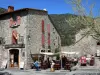 Villefranche-de-Conflent - Maison en pierre et terrasse de café place du Génie ; dans le Parc Naturel Régional des Pyrénées Catalanes