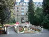 Vittel - Station thermale : hôtel (palace), arbres, escalier et fontaine avec des fleurs