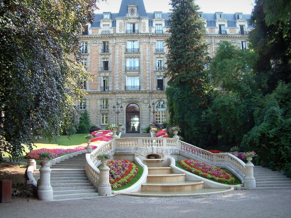 Guide des Vosges - Vittel - Station thermale : hôtel (palace), arbres, escalier et fontaine avec des fleurs