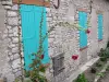 Yevre-le-Châtel - Casa de pedra com venezianas azuis e hollyhocks