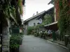 Yvoire - Rua da vila medieval com terraço restaurante, casas com fachadas cobertas de hera, flores e plantas
